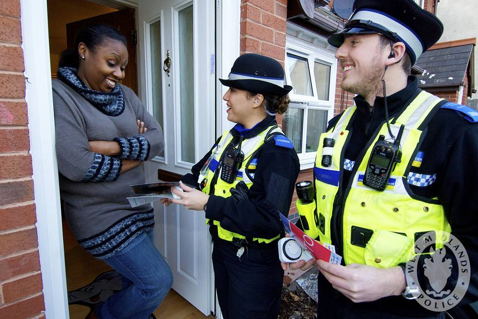 police officers talking to a woman in her door